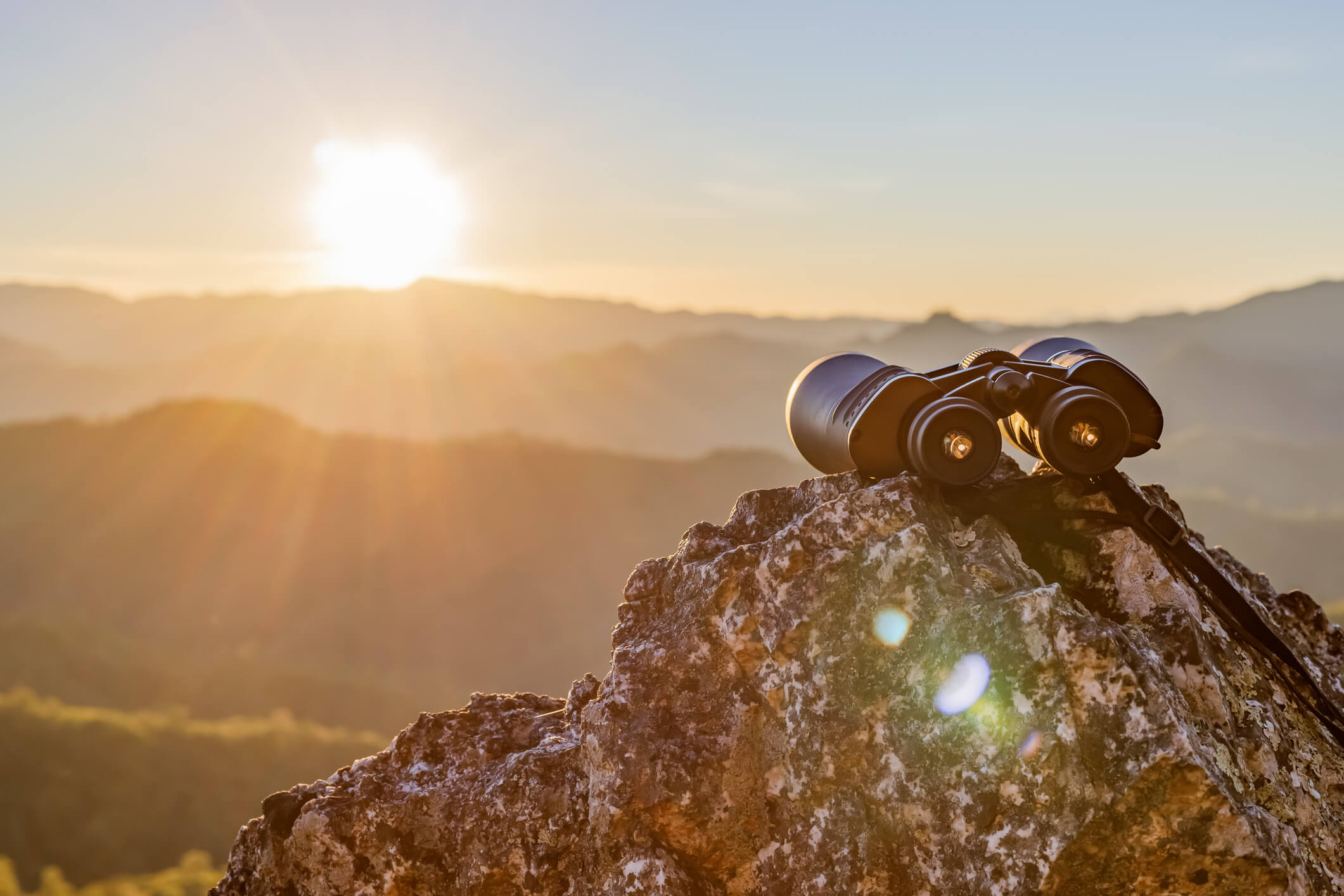 Binoculars-on-Top-of-Rock-Cliff-Sunrise-iStock-1386643491.jpg