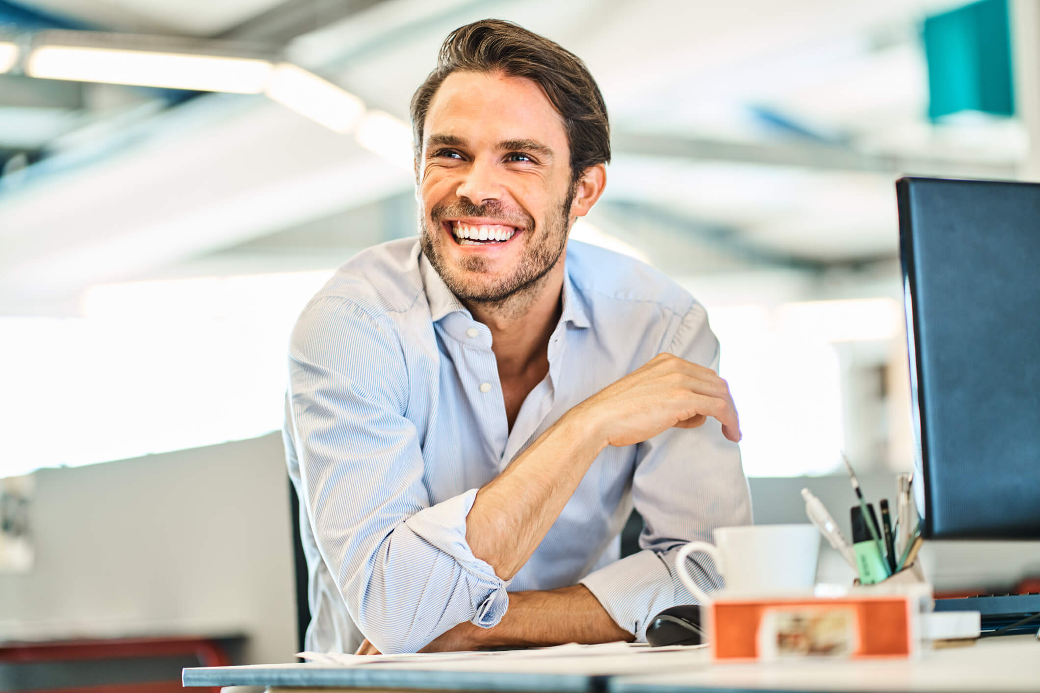 Man-Sitting-at-Desk-Looking-Away-iStock-1256519300.jpg