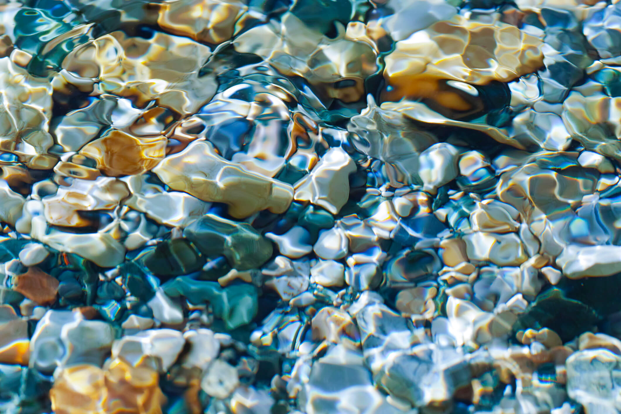 Sun shining on pebbles in a stream