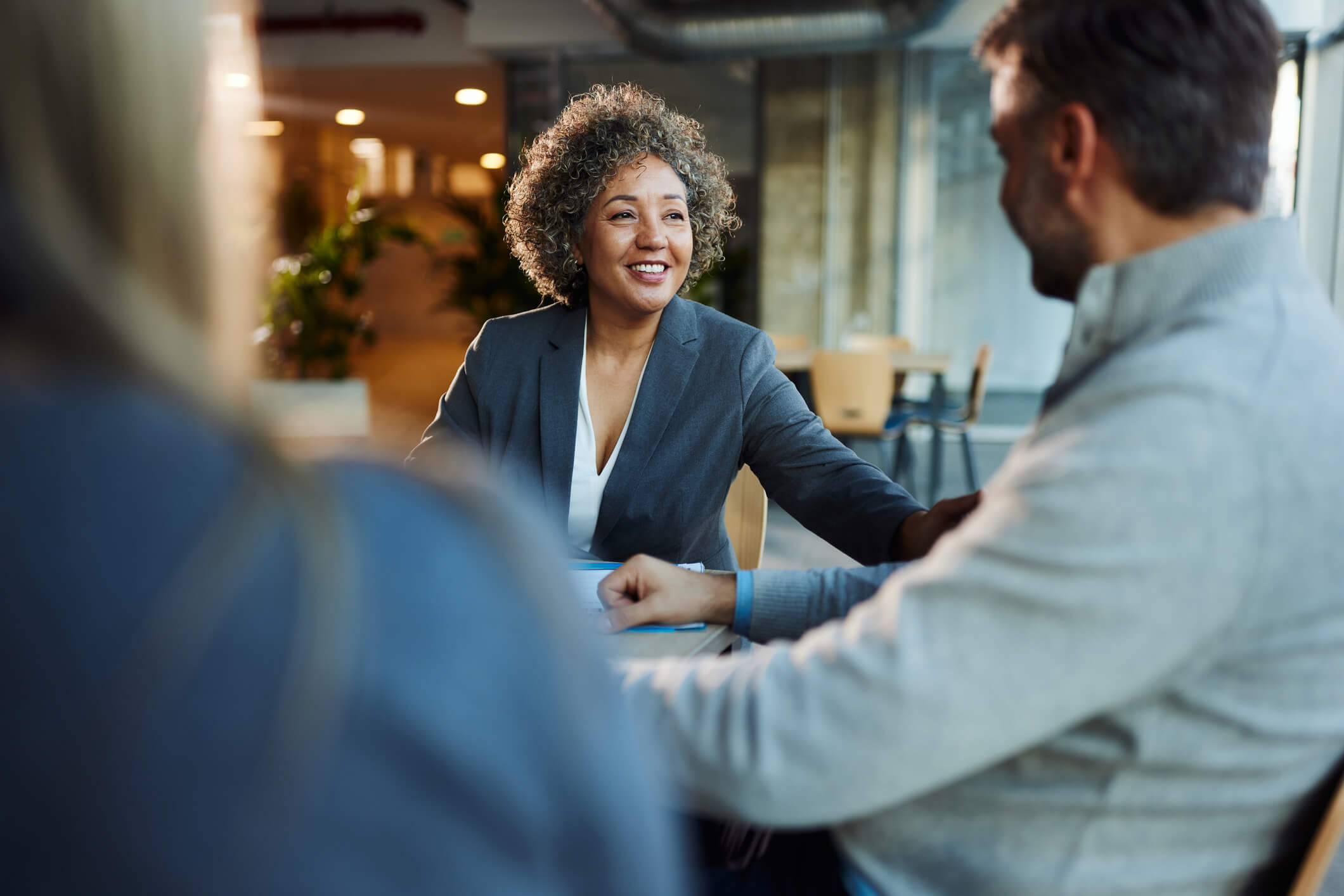 Woman in suit talking to two of her clients